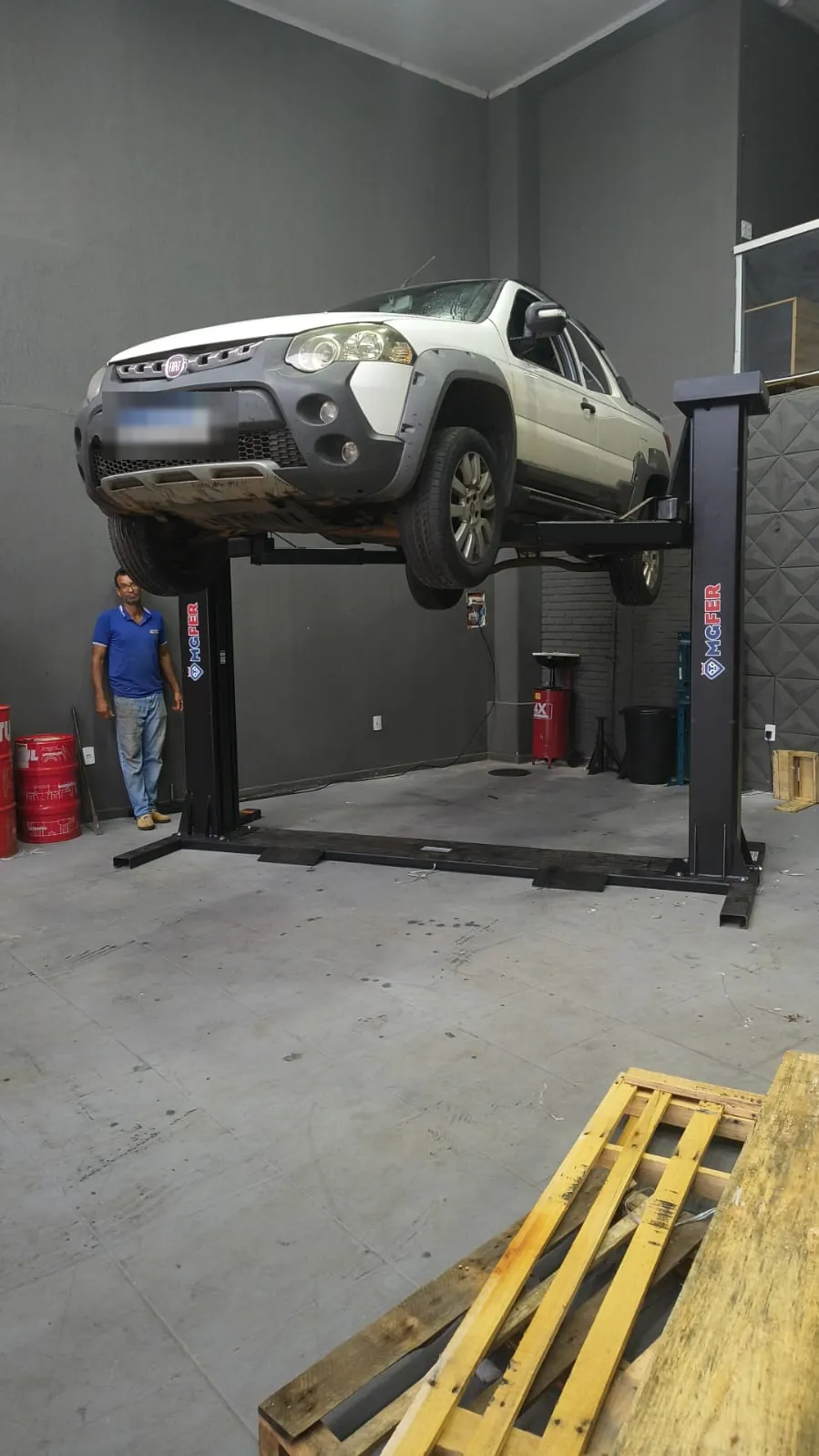 Picape suspensa em elevador automotivo de duas colunas de 2.600 kg em oficina mecânica